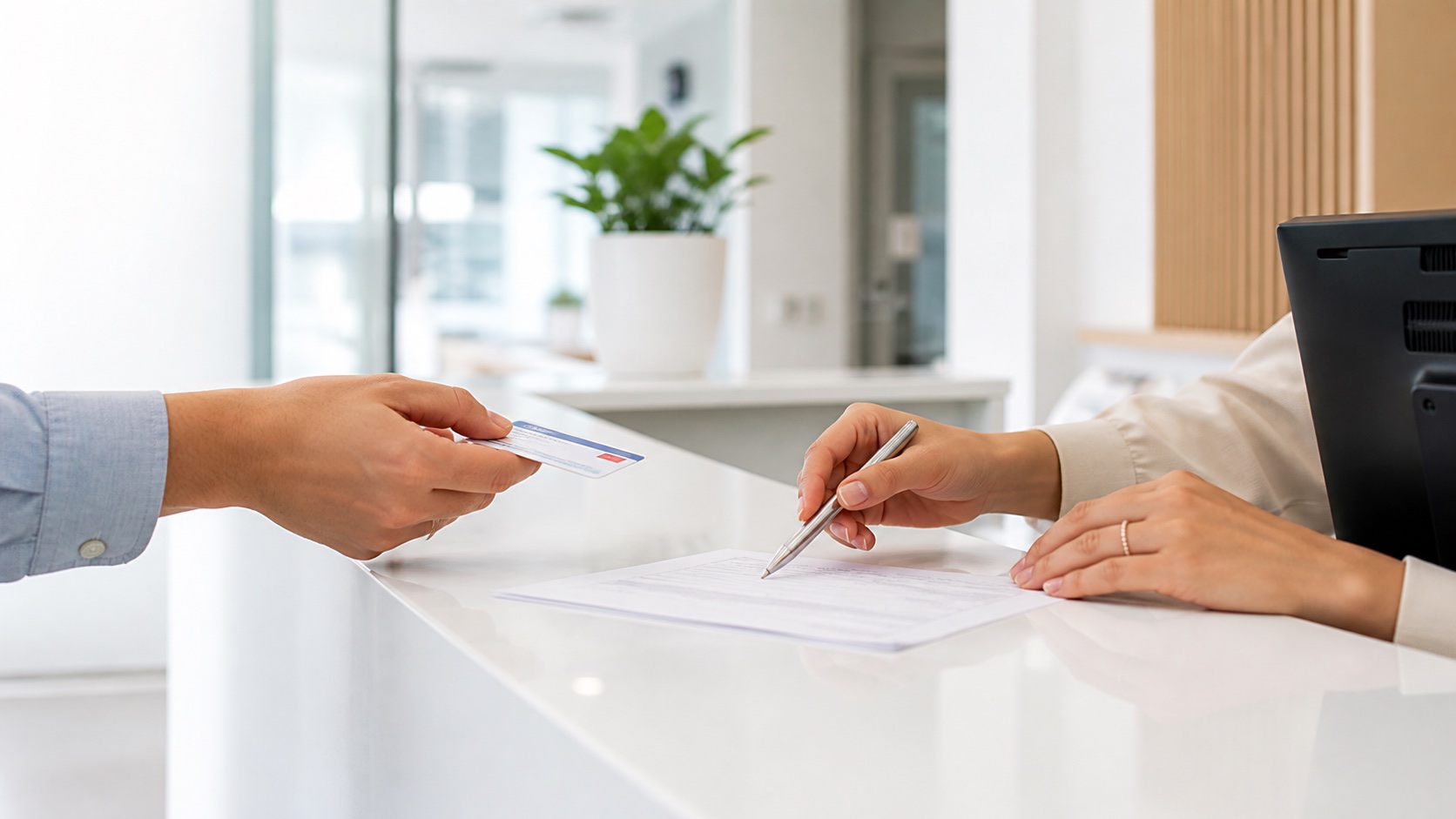 Patient and receptionist reviewing insurance information at a medical clinic